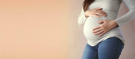 Woman in unzipped jeans applying cream on belly for stretch marks photo