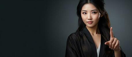 Young Asian woman in bathrobe pointing to empty copy space showcasing beauty photo