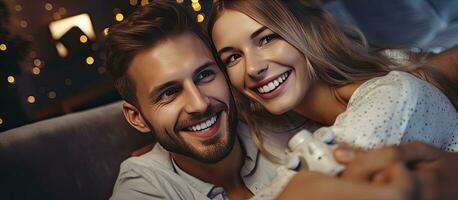 Smiling couple in pajamas playing video game together on the floor at home photo