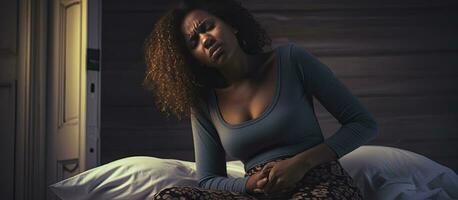 africano americano mujer experimentando estómago dolor a hogar conmovedor su barriga y sufrimiento desde abdominal obstáculo foto
