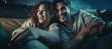 Smiling couple in pajamas playing video game together on the floor at home photo