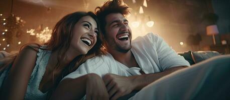 Smiling couple in pajamas playing video game together on the floor at home photo