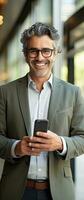 Smiling mature businessman holding smartphone in office using cell phone app for business solutions photo