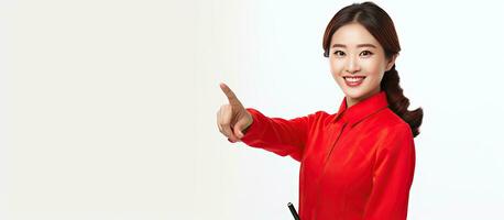 Smiling Asian woman in red outfit pointing with copy space photo