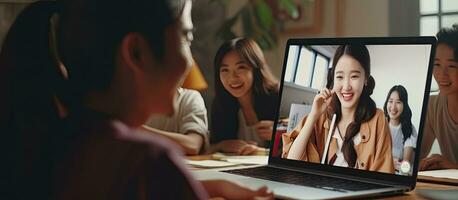 Asian female teacher and diverse students video calling on laptop for distant learning photo