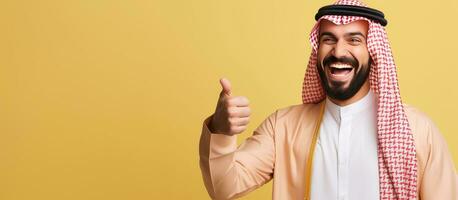 Arab man confidently points towards copy space on yellow background for designers to add text or logos photo