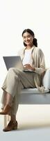 Asian woman sitting on chair using laptop isolated on white with copy space photo