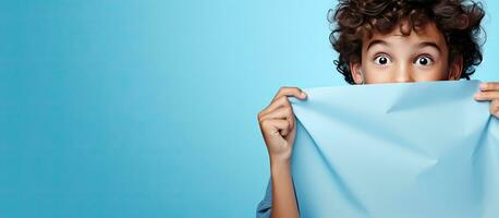 Surprised teenager pointing at blue paper with space for an advertisement photo