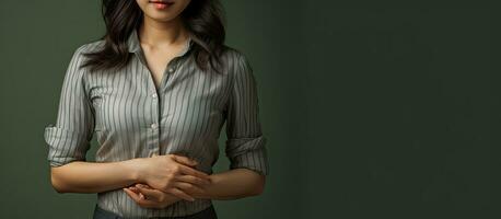 An Asian woman with layered clothing showing an empty palm and resting her other hand on her waist photo