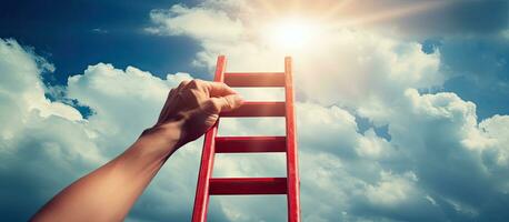 Hand reaches for ladder towards blue sky photo