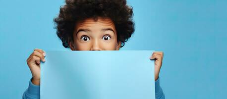 Surprised teenager pointing at blue paper with space for an advertisement photo