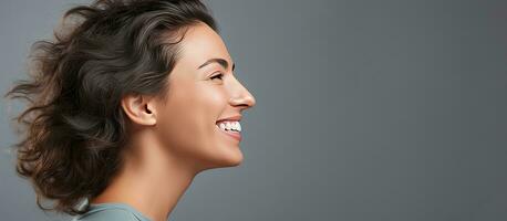 Closeup portrait of a happy woman laughing at a joke gesturing and reacting to a compliment or remark with grey background for adding text photo