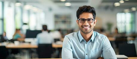 Confident Indian businessman smiling at camera in office copy space photo