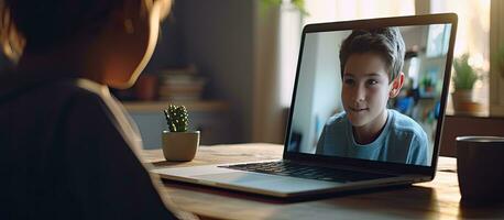 Boy using laptop for video call and distance learning at home photo