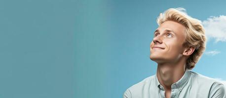 Blond man daydreaming and seeking inspiration gazing into empty space photo