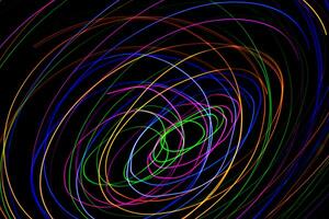 Multi color light painting photography, swirl and curve of blue, green and red light against a black background. photo