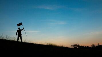 Motivation for trying to succeed in business, Silhouette of man on mountain top over sky and sun light background,business, success, leadership, achievement and people concept photo