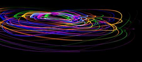 Multi color light painting photography, swirl and curve of blue, green and red light against a black background. photo