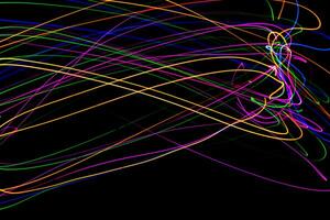 Multi color light painting photography, swirl and curve of blue, green and red light against a black background. photo