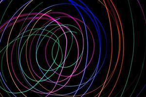 Multi color light painting photography, swirl and curve of blue, green and red light against a black background. photo