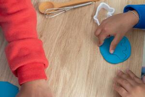 Children's hands and simulation cooking toys in the kitchen counter. photo