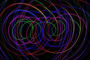 Multi color light painting photography, swirl and curve of blue, green and red light against a black background. photo