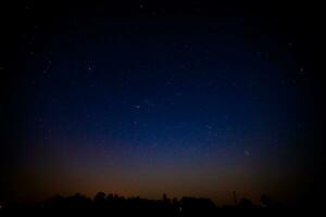 noche paisaje con vistoso y ligero amarillo lechoso camino lleno de estrellas en el cielo. foto