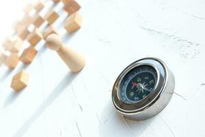 Compass and wooden puppet on a white wooden background, Concept of employee selection photo