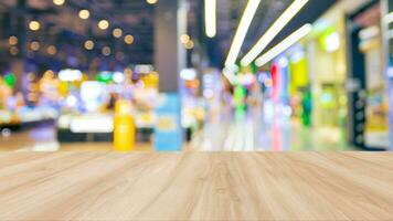 Wooden table top with shopping mall blurred background. photo