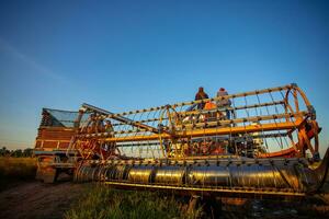 agrícola maquinaria en el arroz campos a puesta de sol foto