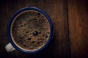 Cup of coffee on wooden background. Copy space. Top view. Flat lay photo