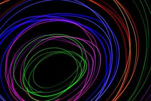 Multi color light painting photography, swirl and curve of blue, green and red light against a black background. photo