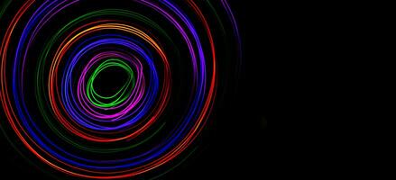 Multi color light painting photography, swirl and curve of blue, green and red light against a black background. photo