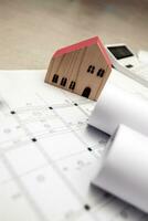 real estate and property, architecture, building, construction concept - Tiny house model on an architect's desk photo