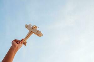 Happy children playing a wooden toy plane On the sunset sky background. photo