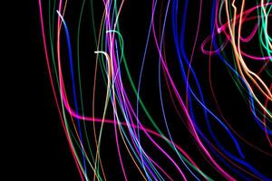 Multi color light painting photography, swirl and curve of blue, green and red light against a black background. photo