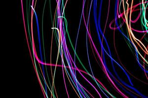 Multi color light painting photography, swirl and curve of blue, green and red light against a black background. photo