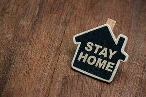 Stay home, Typography campaign poster with text for your own quarantine time. family Motivational quotes to stay safe at home from disease outbreaks. text with the house wooden craft. photo