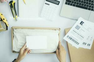 Small business owner packing clothes in the box at workplace. photo