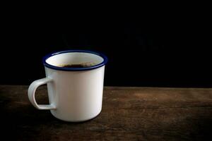 taza de café en antiguo de madera mesa foto