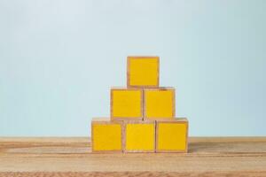 5 yellow painted wooden blocks on a wooden table photo