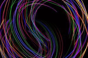 Multi color light painting photography, swirl and curve of blue, green and red light against a black background. photo