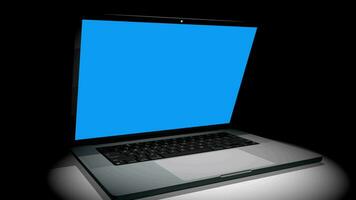 Intro video of  aluminum laptop opens as scene is illuminated and camera pans from above to end in front of blue screen against black background. 3D Animation