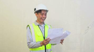 Indonesian worker wear vest and white helmet check report then thinking pose felt happy. The footage is suitable to use for engineer and safety content media. video