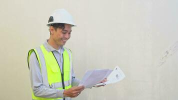 Indonesian worker wear vest and white helmet check report then thinking pose felt happy. The footage is suitable to use for engineer and safety content media. video