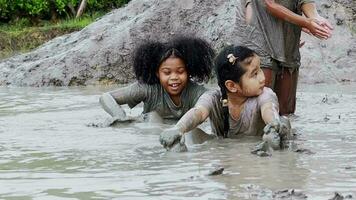 asiático muchachas teniendo divertido atrapando ranas en un barro fosa. aprendizaje fuera de el salón de clases video