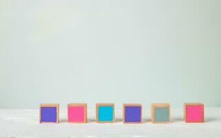 Wooden blocks of many colors arranged on a wooden table, Pastel tones. photo