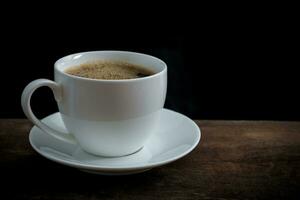 Cup of coffee on old wooden table photo