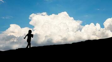 el silueta de un niño corriendo arriba un montaña, éxito y aventuras concepto. foto