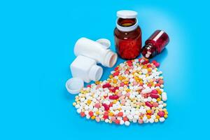 Many pills in the form of a heart Multicolored on a blue background photo